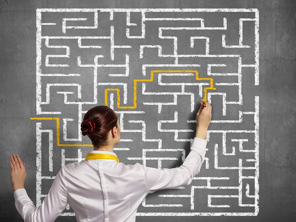 Woman drawing a path through a maze