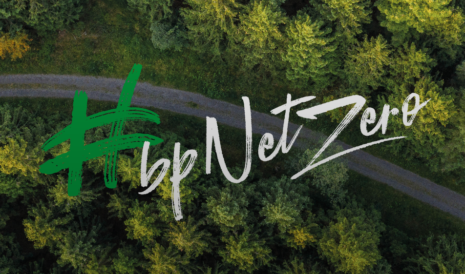 Hashtag BP Net Zero imposed over a winding road through forested area