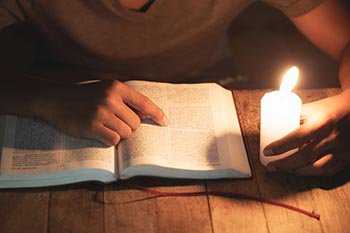 Child studying by candle light